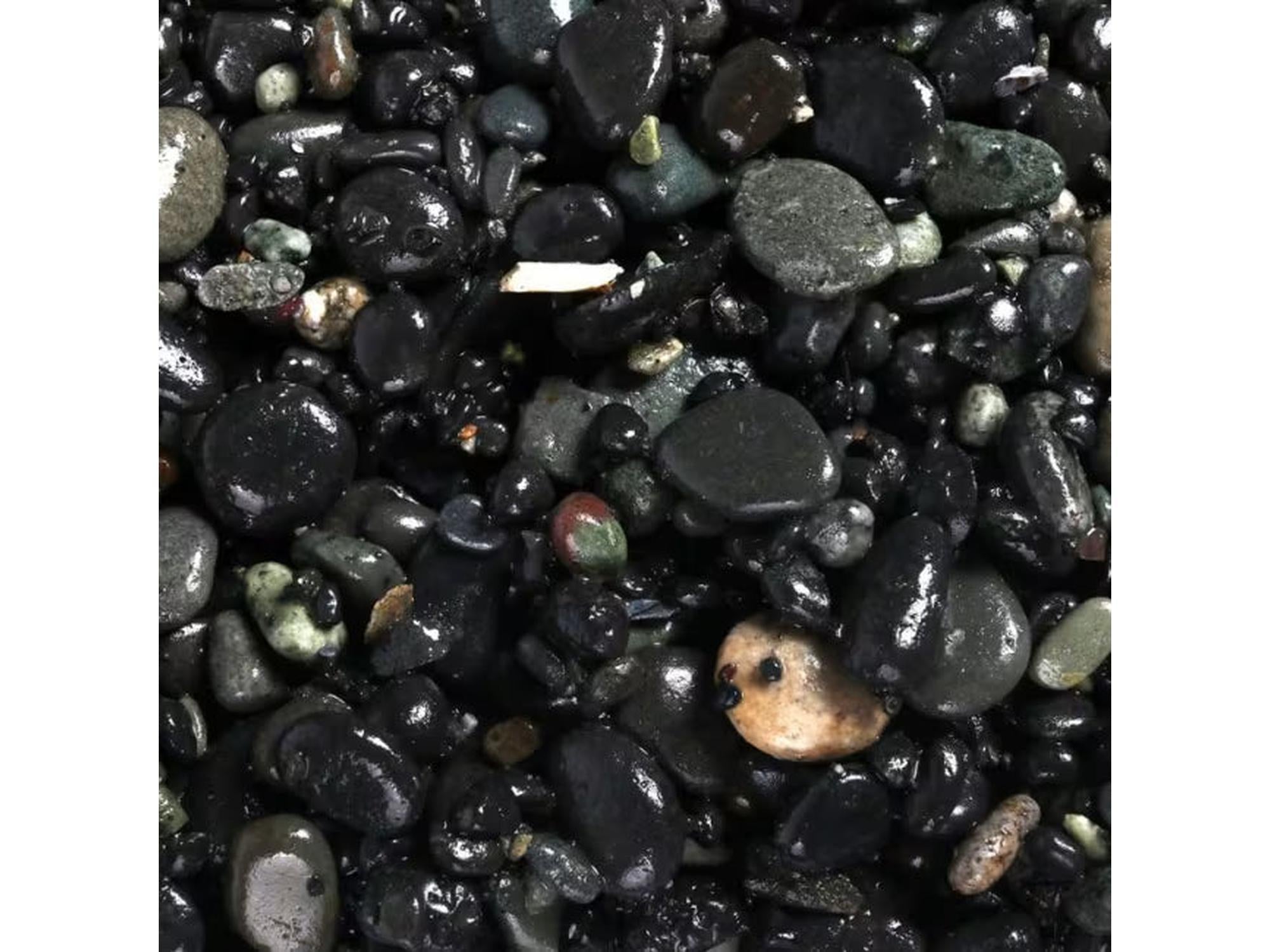 Nærbilde av Akv. Grus Vulcano Sort 2–5 mm, skinnende mørke akvariesteiner i varierende størrelser.