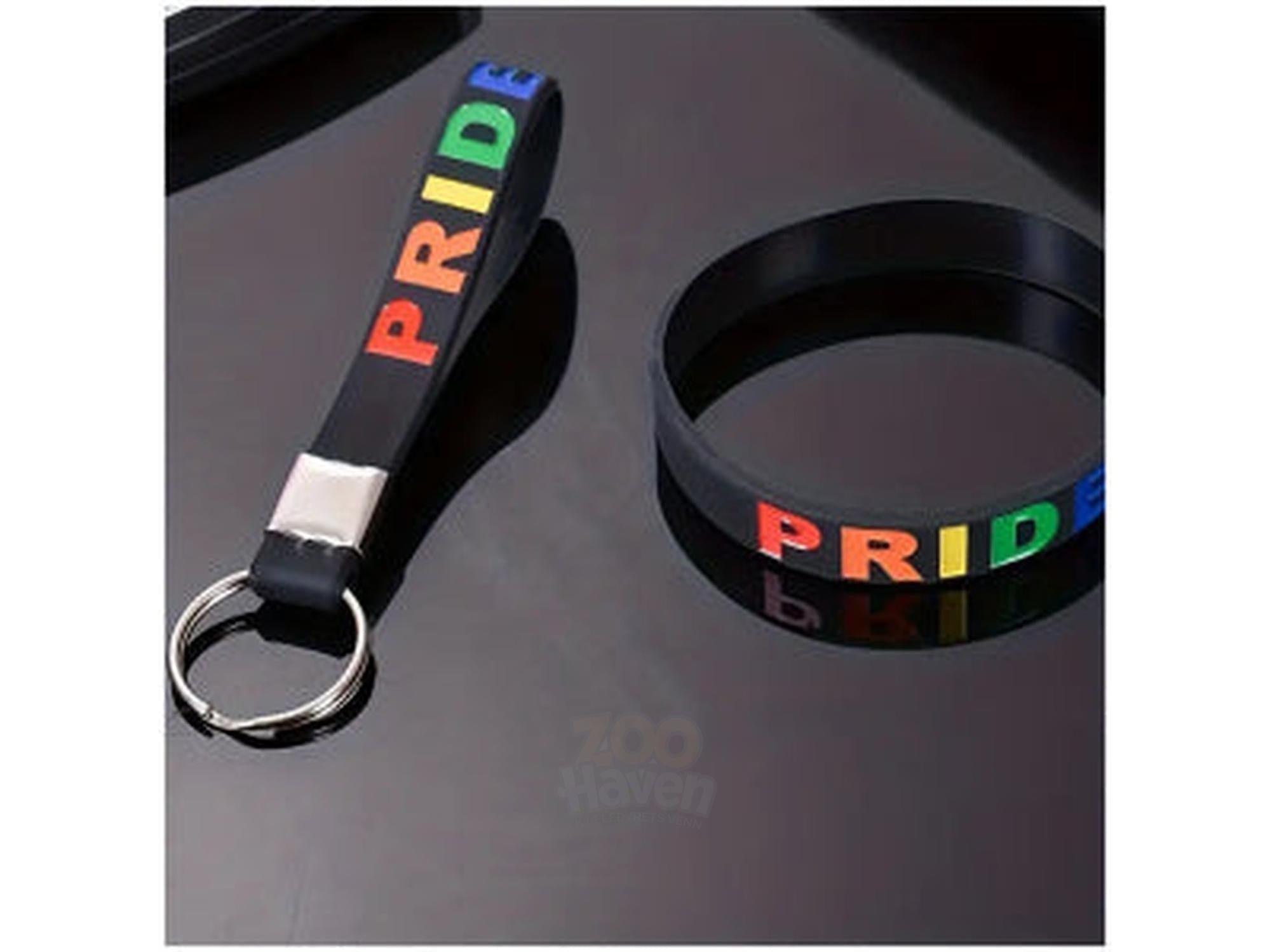 Svart silikonarmbånd og nøkkelbånd med "PRIDE" i regnbuefarger.