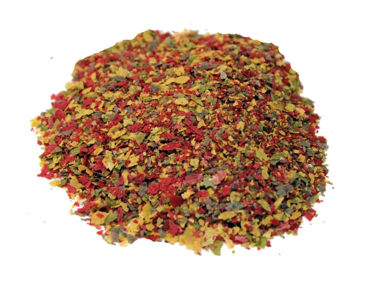 Pile of colorful micro-sized baby fish flakes in red, yellow, and green.