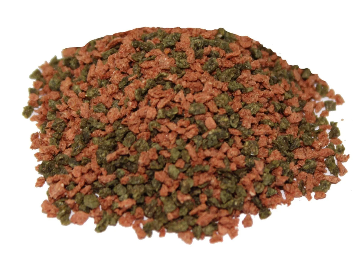 Biogran Medium Granules 45gr 10kg: En haug med rødbrune og mørkegrønne akvariefôrgranulater.