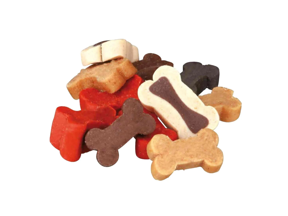 En haug med Bony Mix hundesnacks i ulike former og farger, inkludert bein og labber.