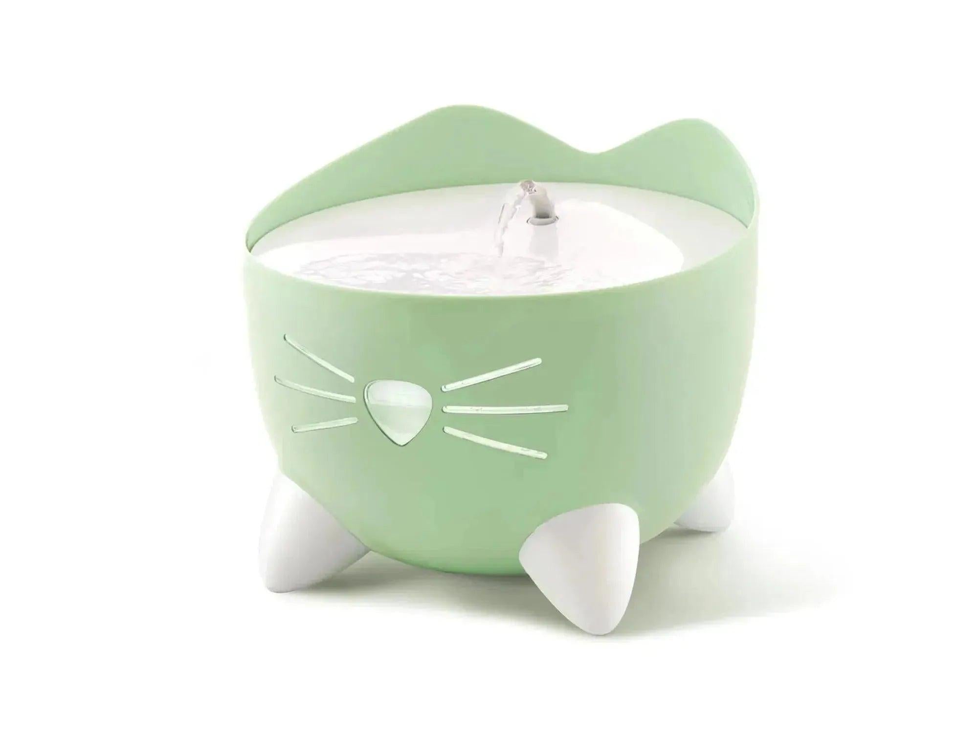 Lysegrønn Catit Pixi drikkefontene med katteansiktsdesign, hvit nese og poter, og sirkulerende vannstråle.