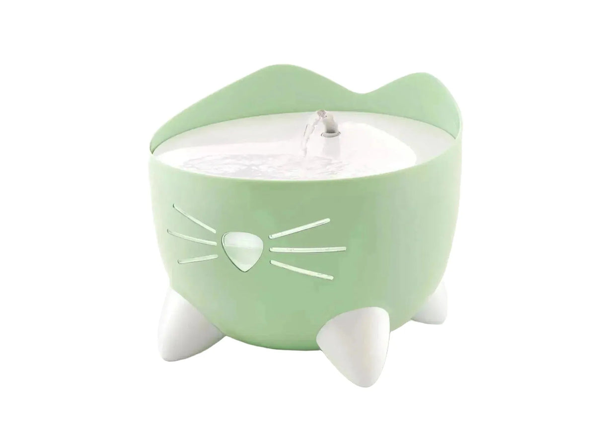 Lysegrønn Catit Pixi drikkefontene med katteansiktsdesign, hvit nese og poter, og sirkulerende vannstråle.
