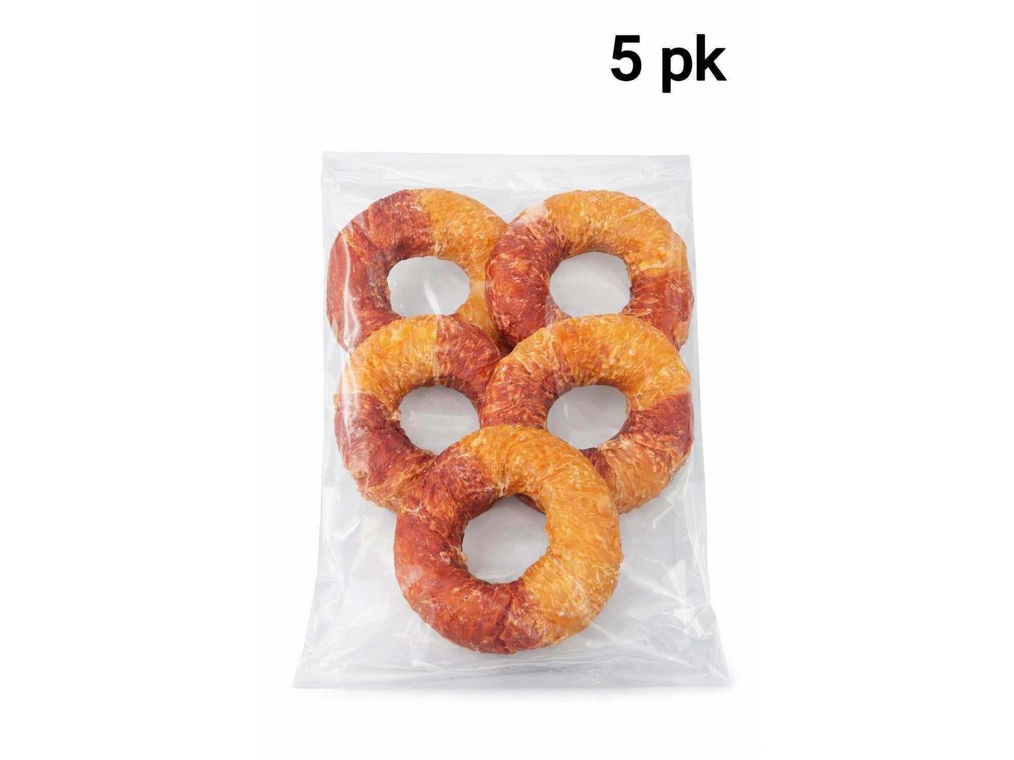 Fem Dentafun tyggeringer for hund, pakket i klar plast, med kylling og and i oransje og rødbrune nyanser.