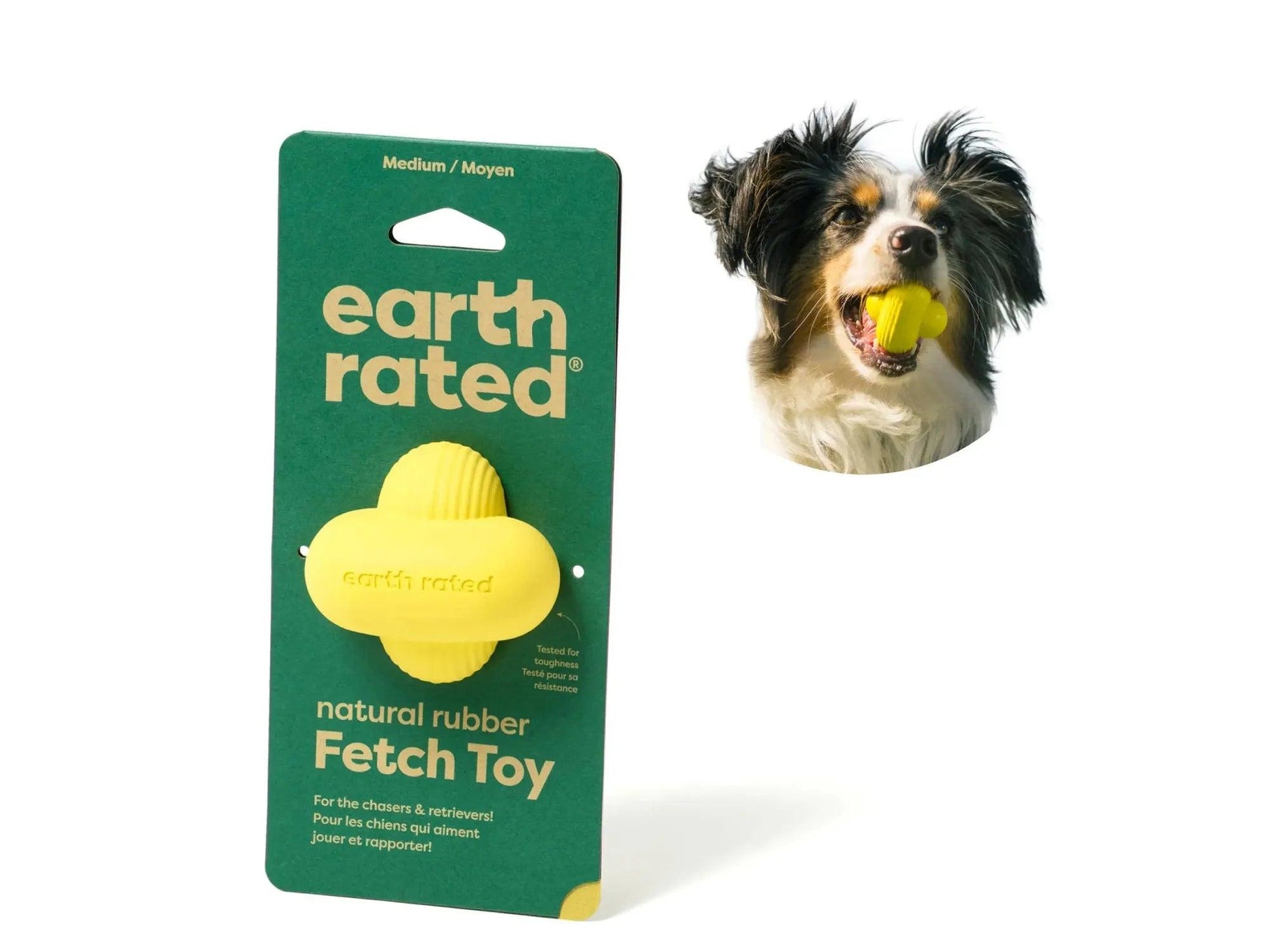 Gul Earth Rated Fetch Toy i naturgummi på grønn emballasje, med en hund som leker med den.