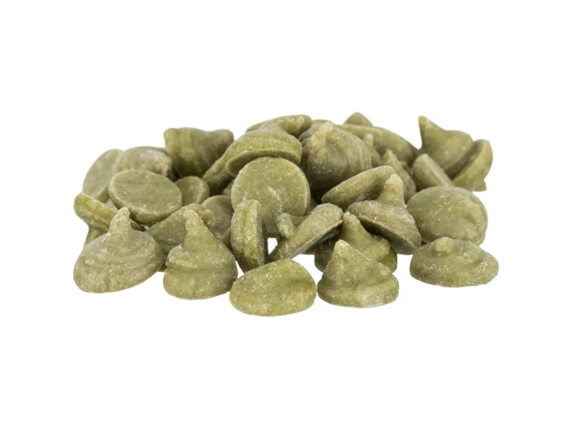 Haug med grønne, ertedrops-formede gnagersnacks med vitaminer og mineraler.