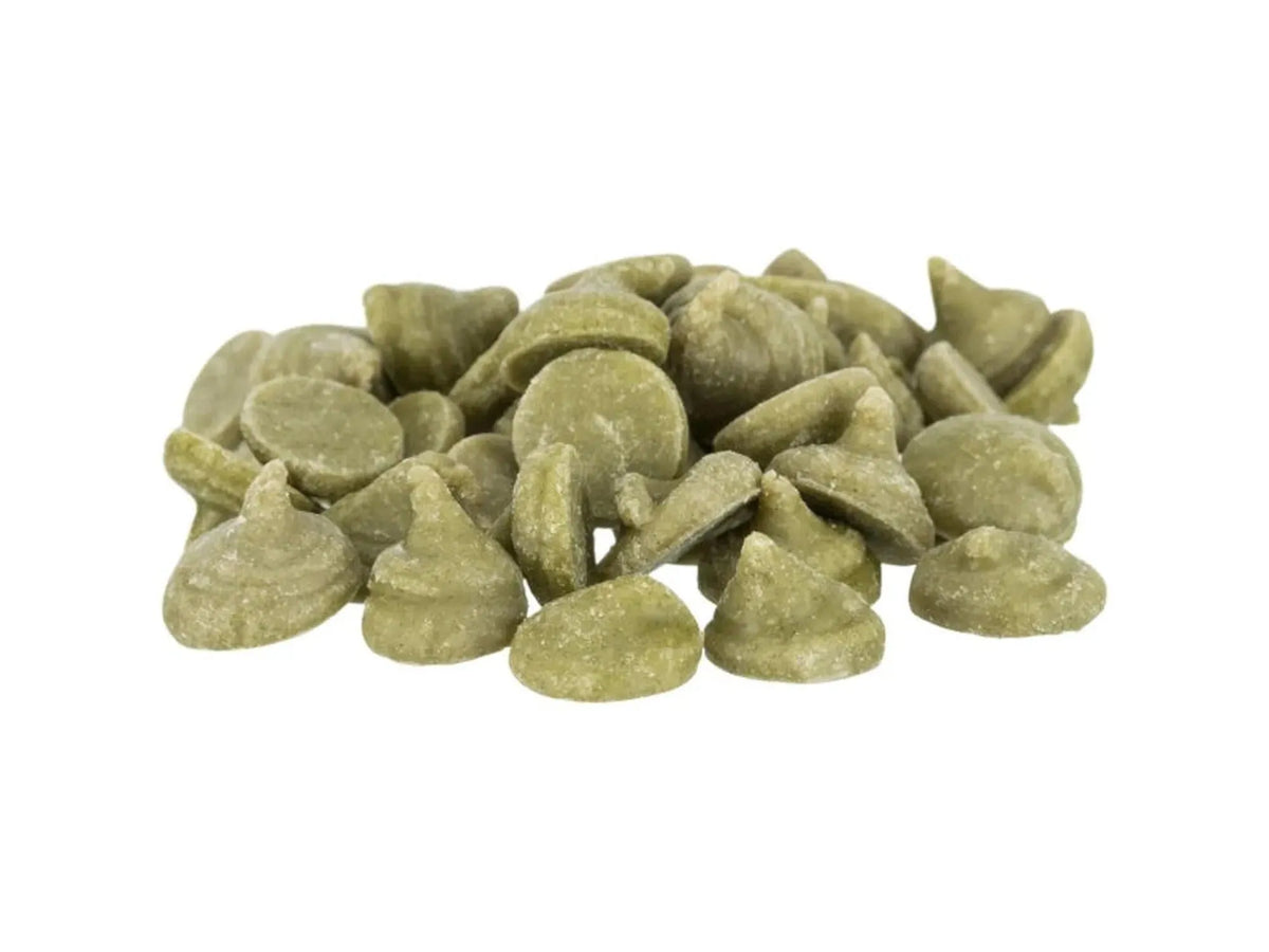 Haug med grønne, ertedrops-formede gnagersnacks med vitaminer og mineraler.