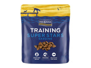 Fish4Dogs Training Super Stars Sardine 150g, blå pose med hundegodbiter og illustrasjon av hunder ved vannet.