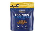Fish4Dogs Training Super Stars Sardine 150g, blå pose med hundegodbiter og illustrasjon av hunder ved vannet.