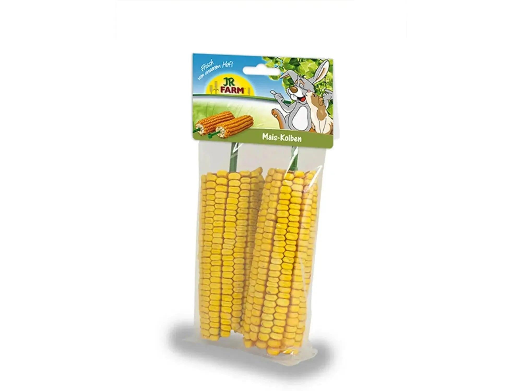 To tørkede, gule maiskolber i en gjennomsiktig plastpakke med JR Farm-logo.