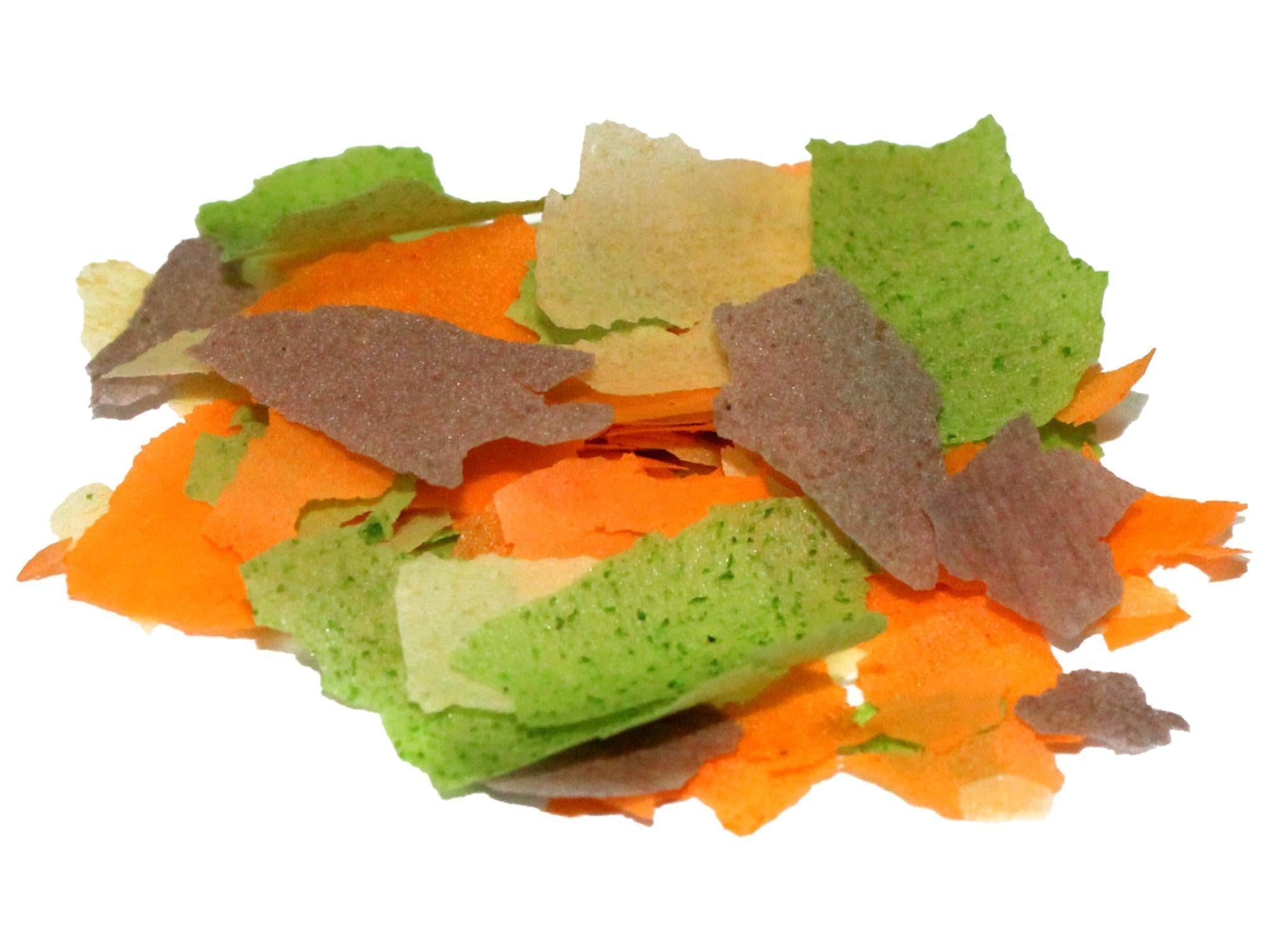 Prodac Goldfish Flakes i en haug med grønne, oransje og brune flak for gullfisk.