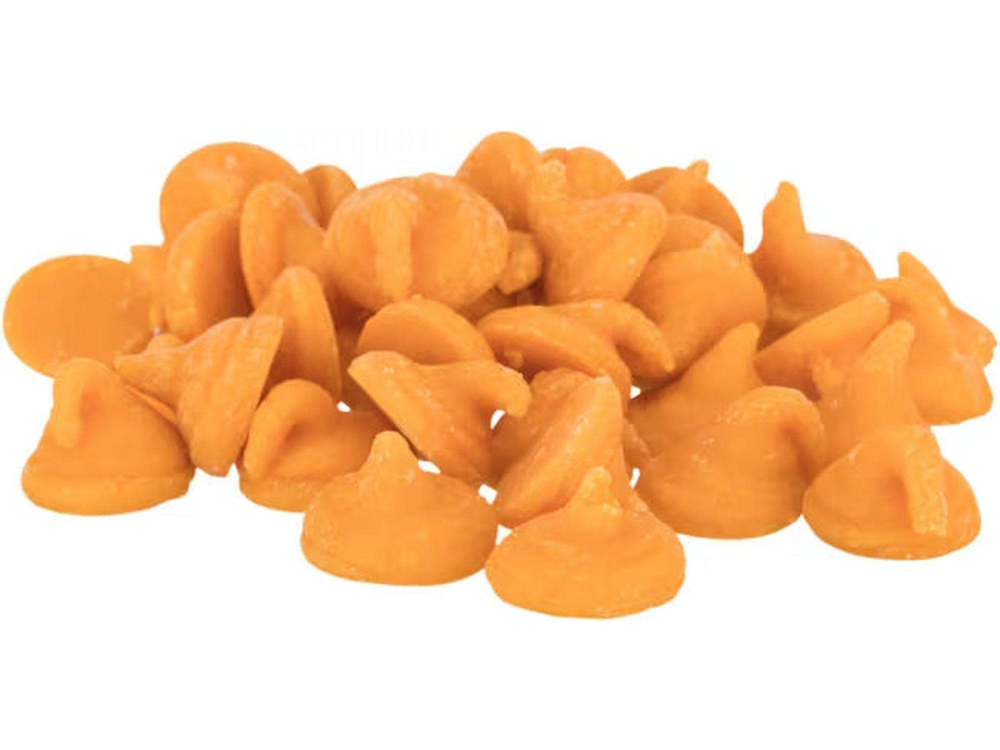 En haug med oransje, dråpeformede gulerotdrops for gnagere, med vitaminer og mineraler.