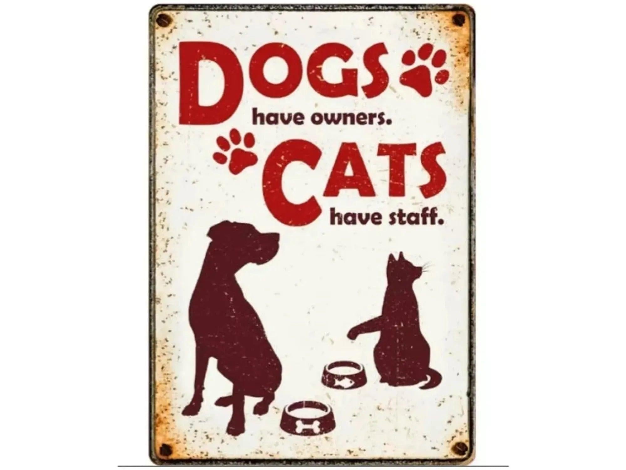 Vintage metallskilt med rød tekst "Dogs have owners. Cats have staff." og silhuetter av hund, katt og matskåler.