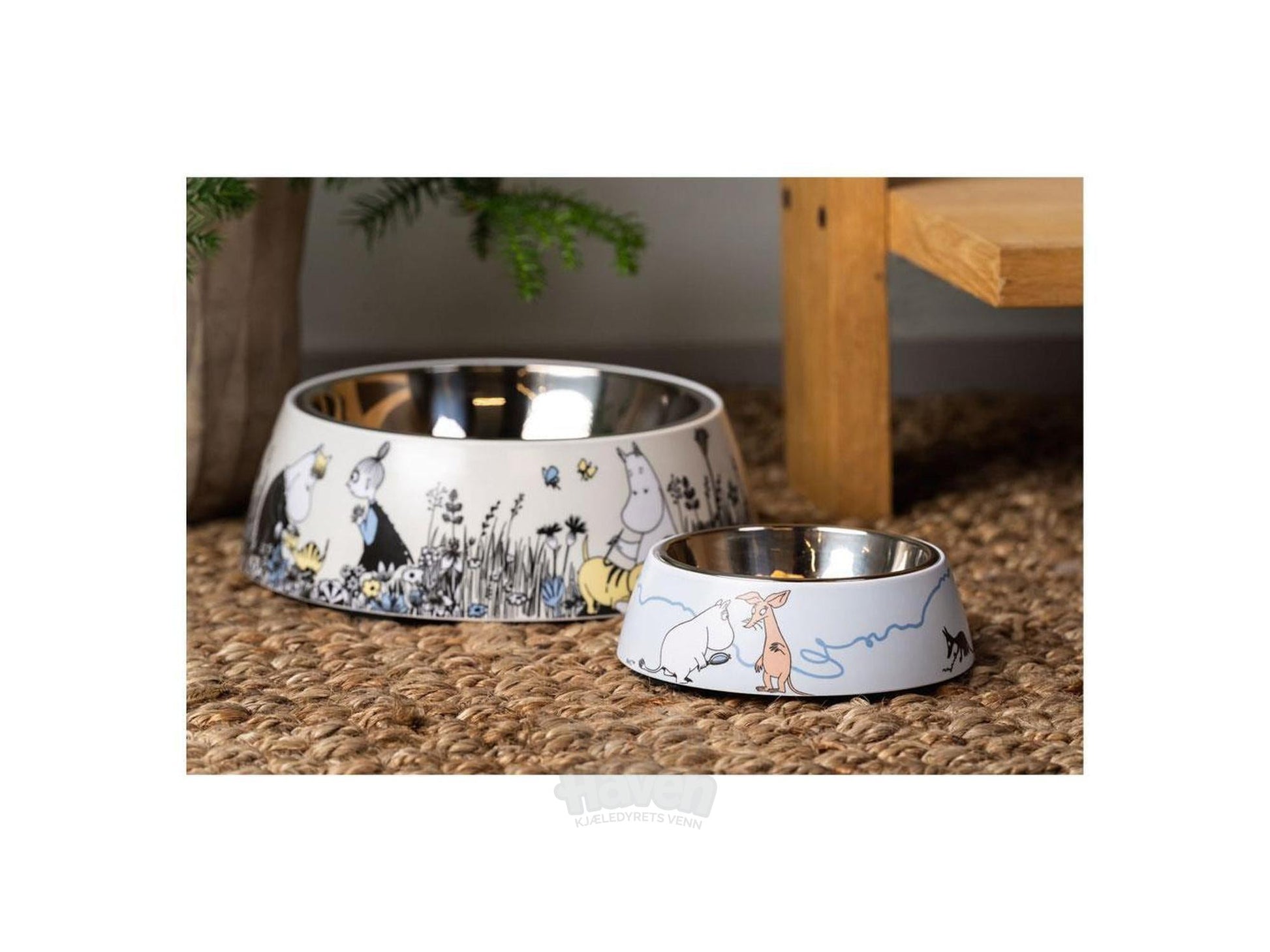 To Mummi Pets matskåler i blått og hvitt med Mummi-motiv, den ene stor og den andre liten, på et flettet underlag.