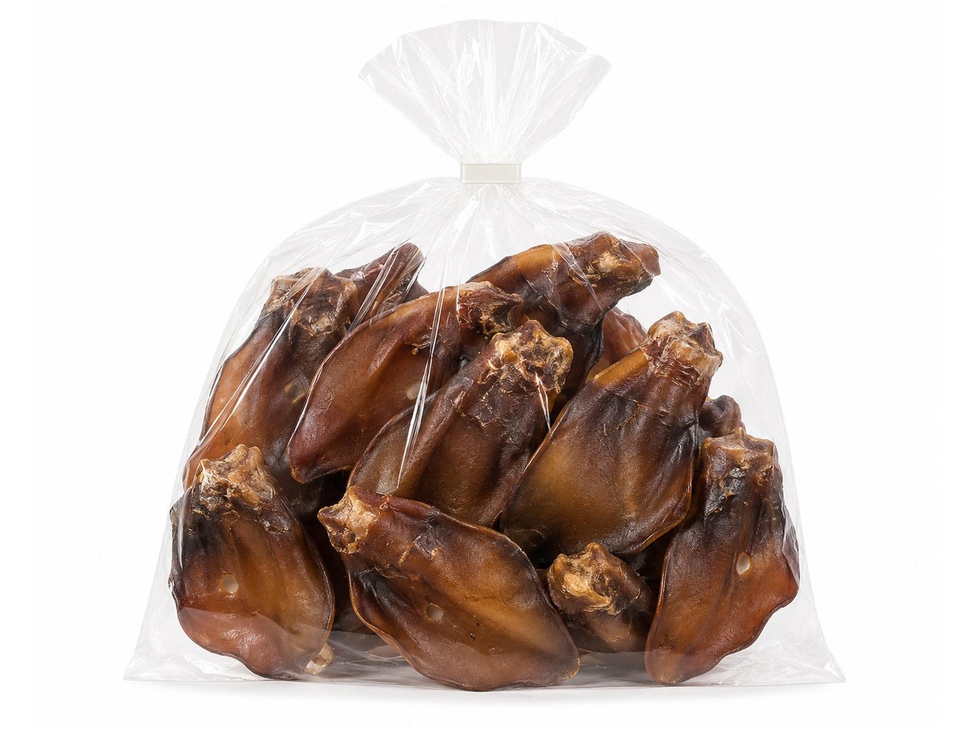 Tørkede okseører med brusk i en gjennomsiktig plastpose, naturlig hundesnacks med mørkebrun farge.