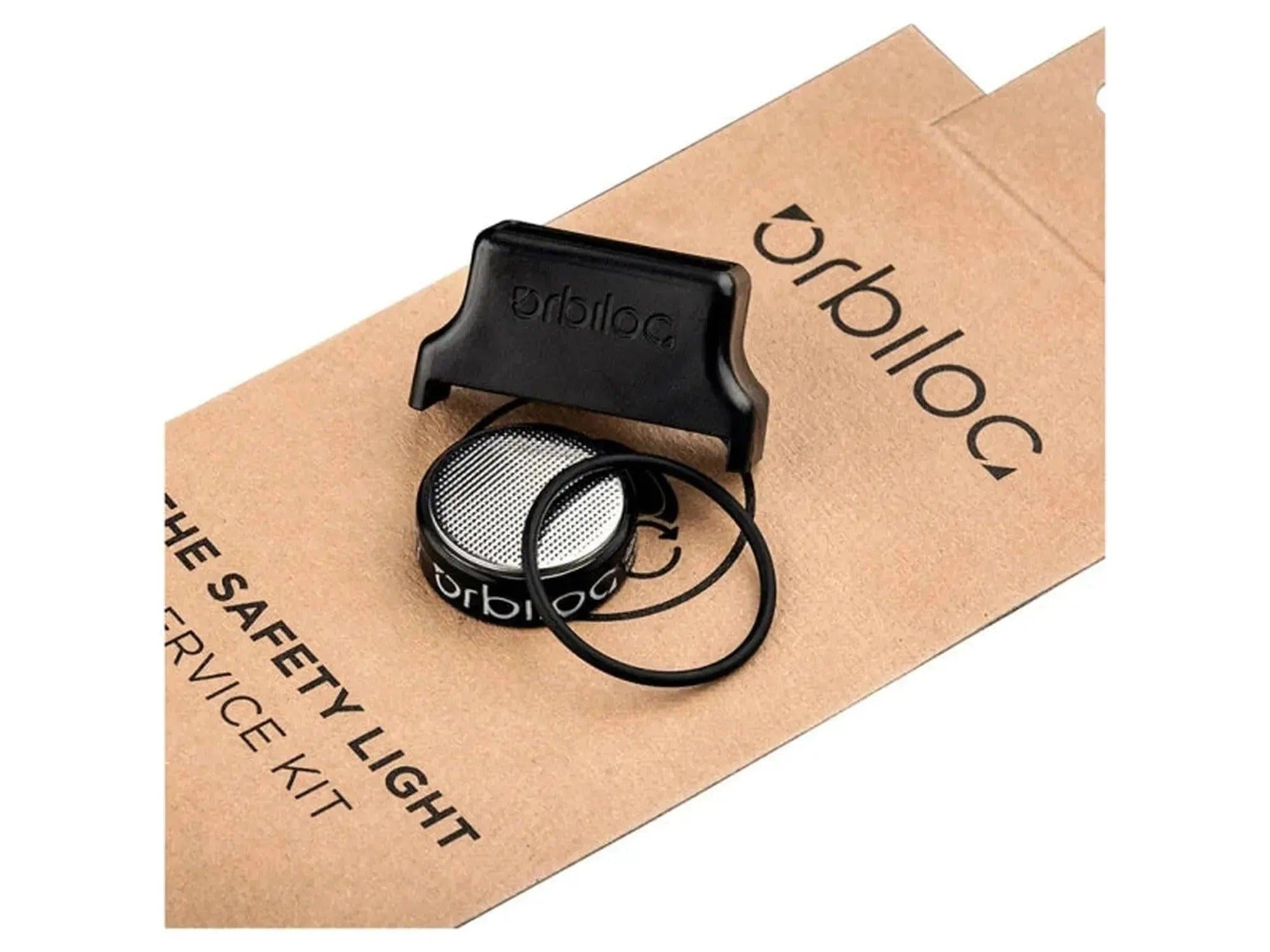 Orbiloc Service Kit med svart verktøy, batteripakke og O-ring på brun pappemballasje.