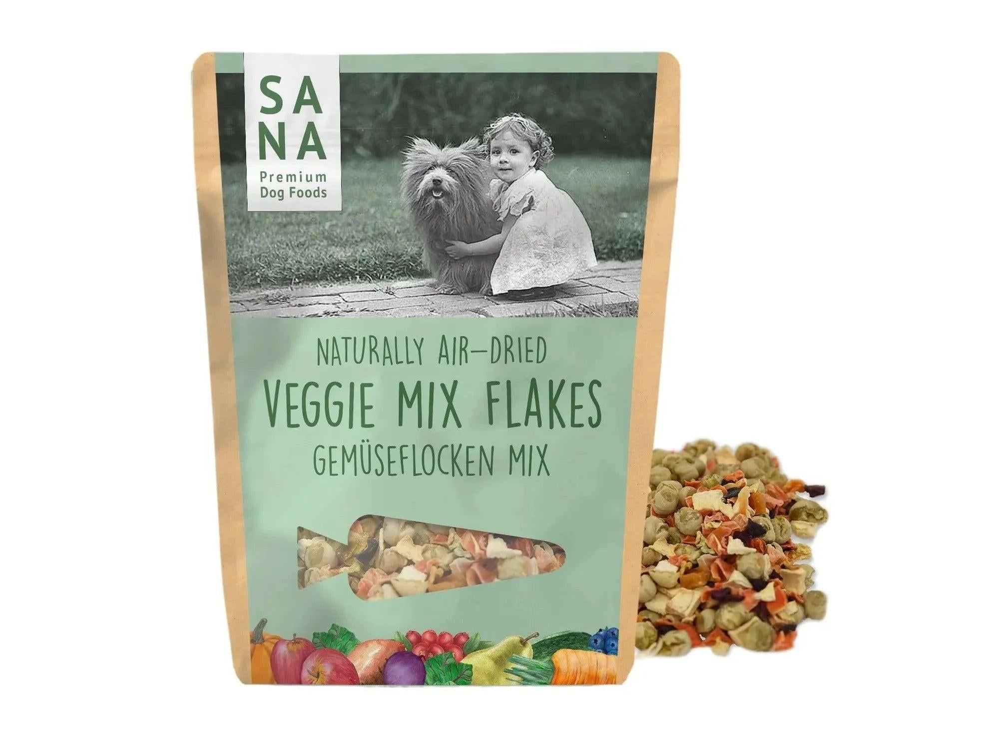 SANA Vegetable-Mix Flakes hundefôr i brun pose med bilde av barn og hund, grønnsaksflak ved siden av.