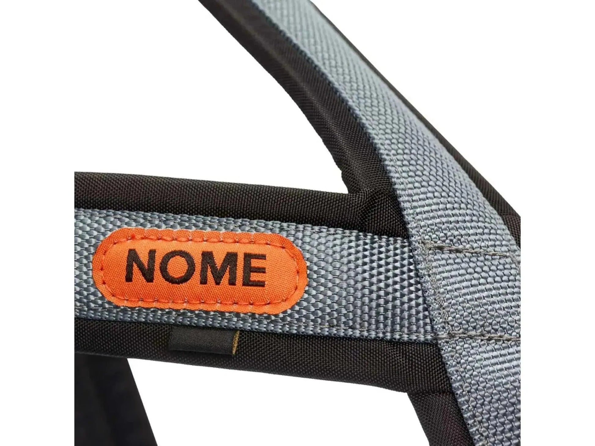 Nærbilde av Seleverkstedet Nome Racing trekksele i svart og grått med oransje "NOME" logo.