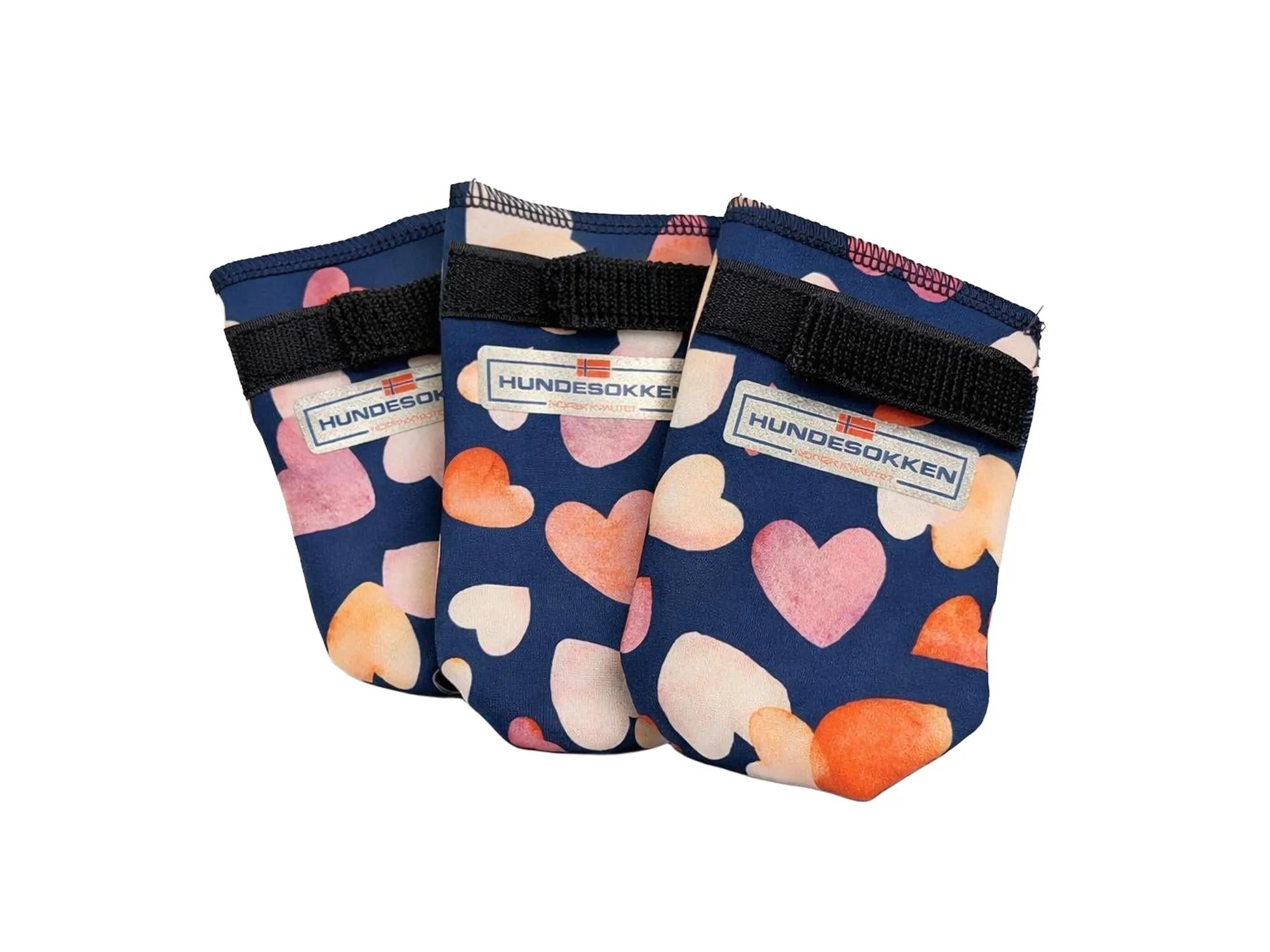 Tre mørkeblå softshell hundesokker med rosa og oransje hjerter, fleecefôr og borrelås.
