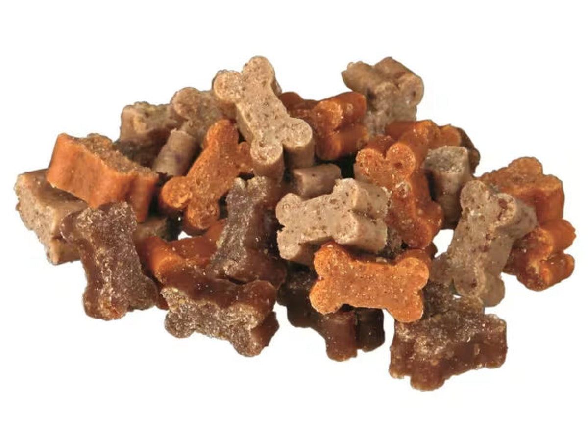 En haug med myke, benformede hundesnacks i ulike brune nyanser, med biff, lam og fugl.