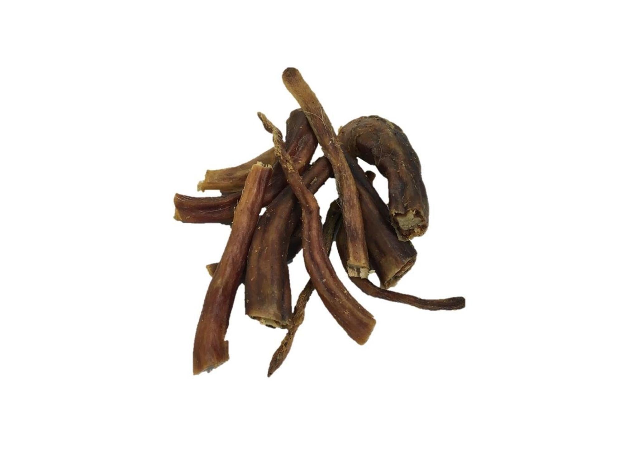 En haug med tørkede, brune grisehaler for hund, naturlige tyggegodbiter.