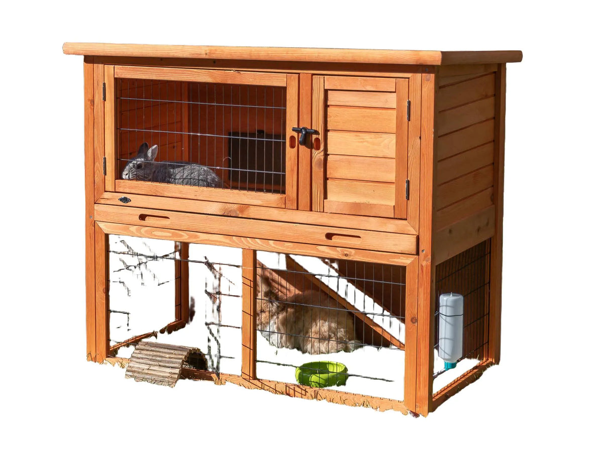Trixie Natura utendørsbur i tre med to etasjer, metallgitter og to kaniner på grønt gress.