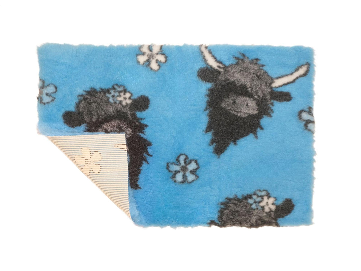 VetBed Nonslip liggematte i 100x75 cm med highland-ku-motiv på blå bunn.